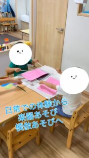 割り箸をバチに見立て、画用紙に描いた丸を叩いて、太鼓・ドラムを表現してあそんでいます。🥁
幼稚園や保育園で体験したことや、この夏に見たお祭りがきっかけとなり、自発的なあそびに取り入れていました。

画用紙に描かれた○を目で確認し、その位置を的として意図を持ち狙いながら叩くことで、視覚的な注意を向ける力や物の位置関係を把握する空間認知の力も育むことができます。

両手に割り箸をもって太鼓を叩くあそびでは、左右の手を同時に、または交互に動かす必要があります。このような動作を繰り返すことで、左右と手をバランスよく使う練習にもなり、左右の手を協力させて動かす”協調運動”の力が育まれます。

音が鳴っていることに気づいて、「やりたい！」とお友だちが声をかけてきてくれたので、二人でセッションを始めました。
お友だちの動きを模倣しながら、「やー！」と言って、バチでポーズを決めている姿もあります。
割り箸同士で擦り合わせて叩くとカチカチ、画用紙に描いた太鼓を叩く音はコツコツという音の変化も楽しんでいます。
机上に新聞紙を敷いて、クッションにすることで、柔らかい音色になることもあります。

身のまわりにある素材の中から、自分たちで見つけた“バチ”や“たいこ”を使って、「これ使えるかも！」「こんな音がする！」と試しながらあそびを広げていく姿があり、
大人が用意したものだけでなく、自分の発想でつくり出すあそびは、よりワクワクが詰まっている様子がみられます。

他にも、作った太鼓だけではなく、ぷれらぼに置いてある“カリンバ”と大人が歌い、合奏をしたこともありました。
お友だちの真似をしたり音の変化や相手と合わせる事も楽しみながら、関わりをもってあそんでいます。

#療育
#保育
#発達支援
#児童発達支援 
#全ての学びはあそびから